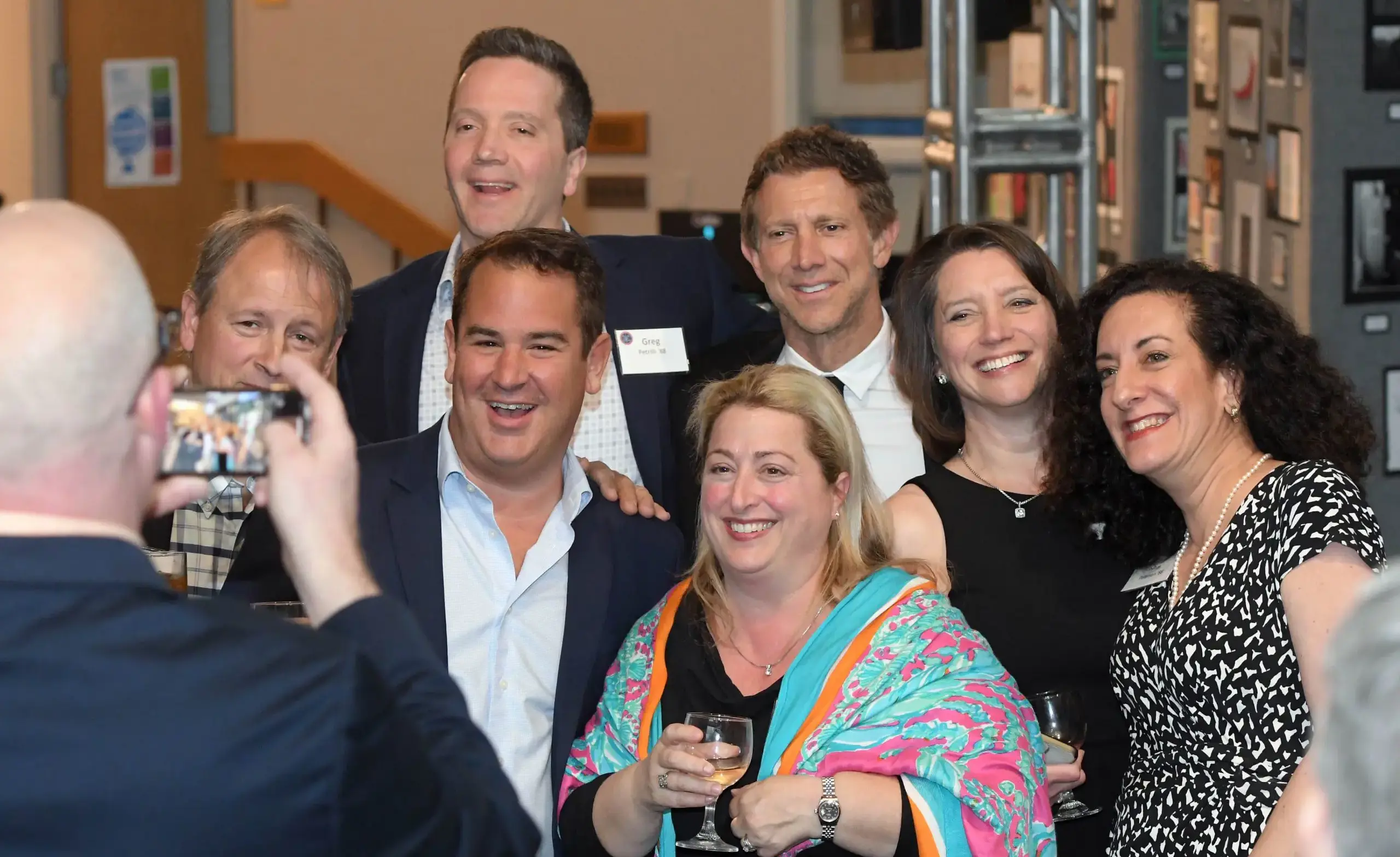 Photograph being taken of a group of smiling Alumni at an event.