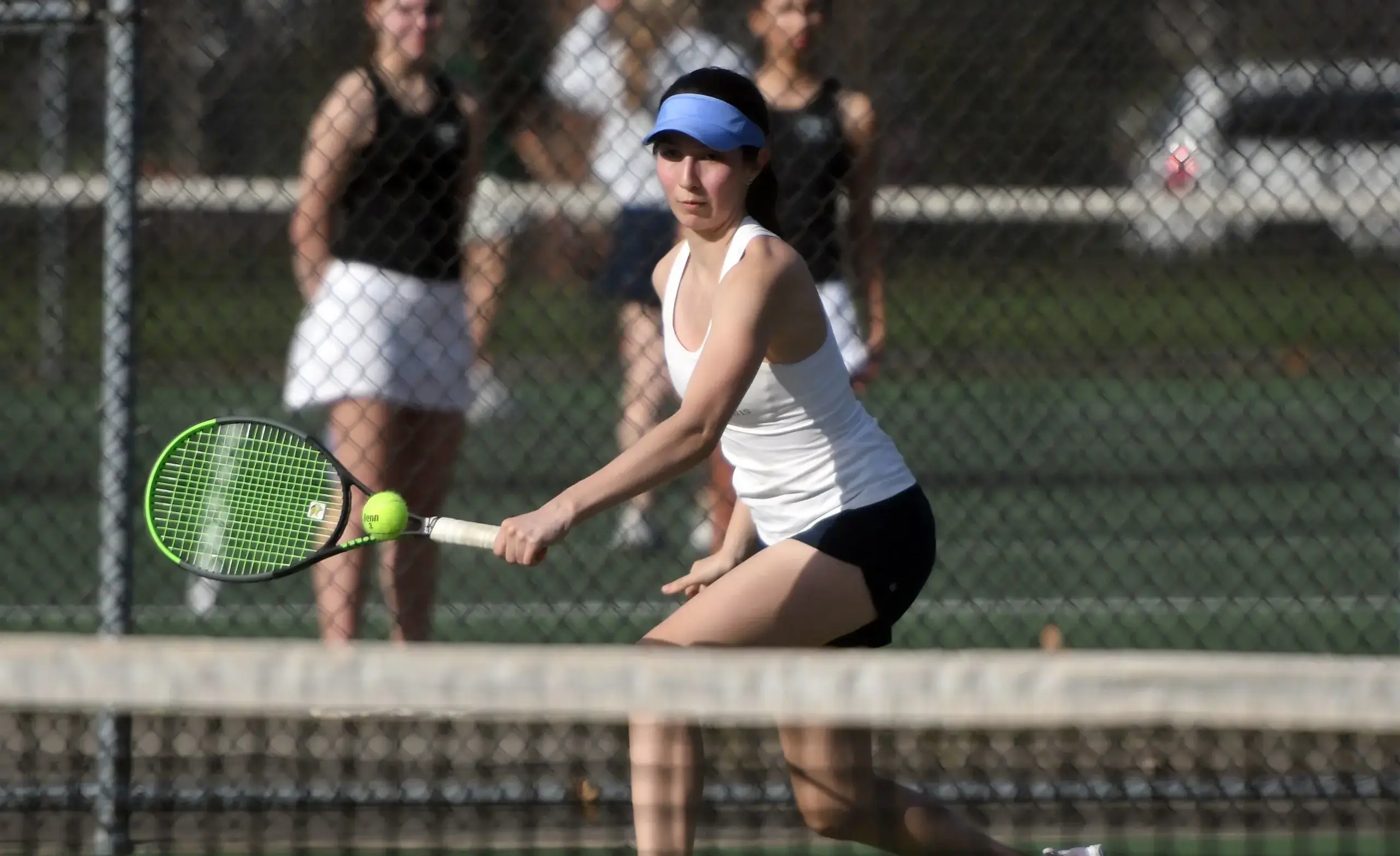Tennis player swings racket at ball