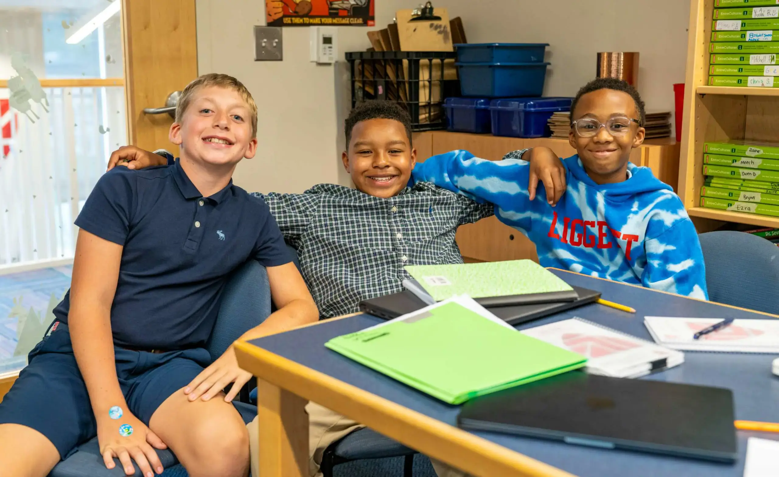 Three middle school students smile together