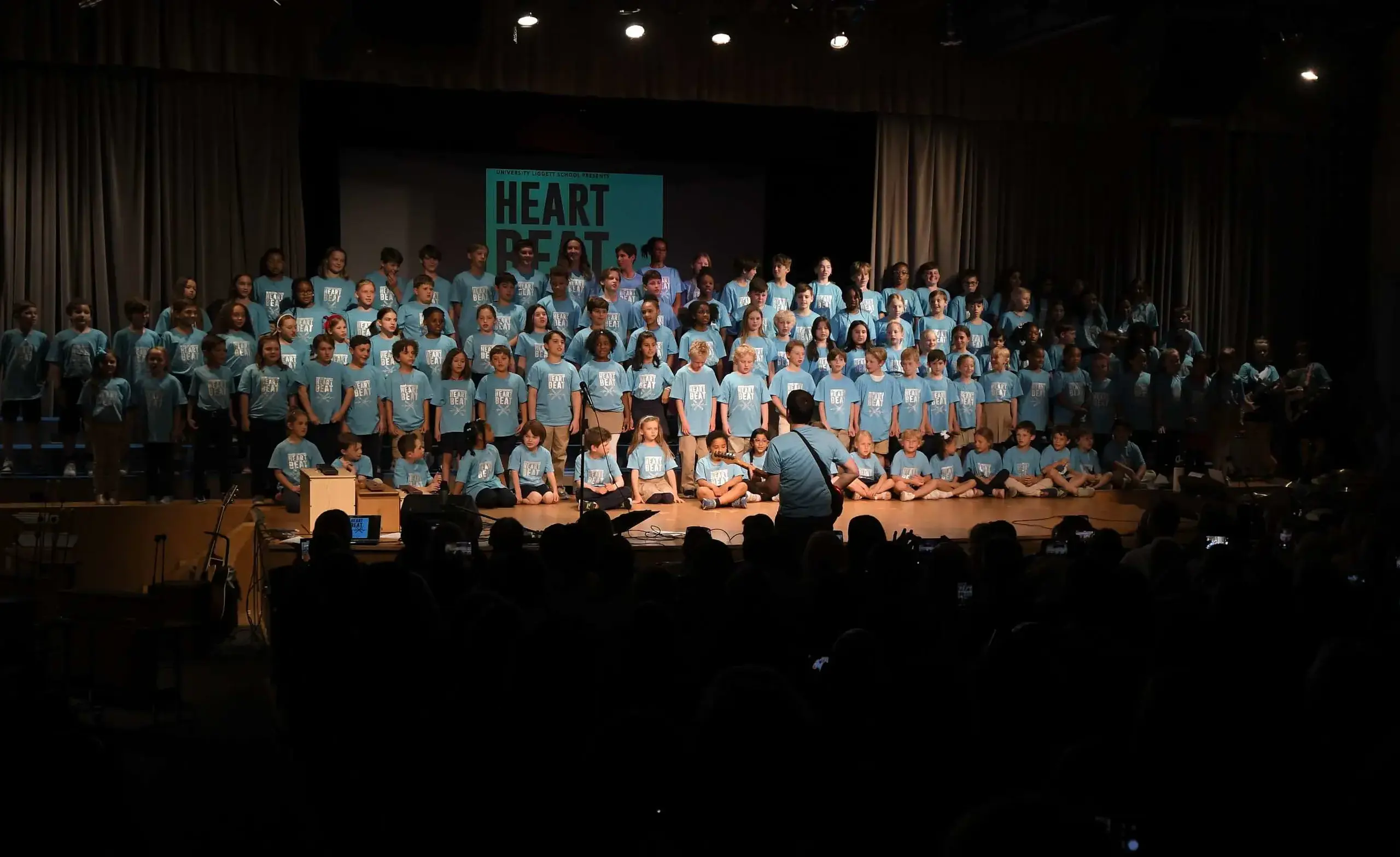 Lower school students from many grades together on stage for community song.