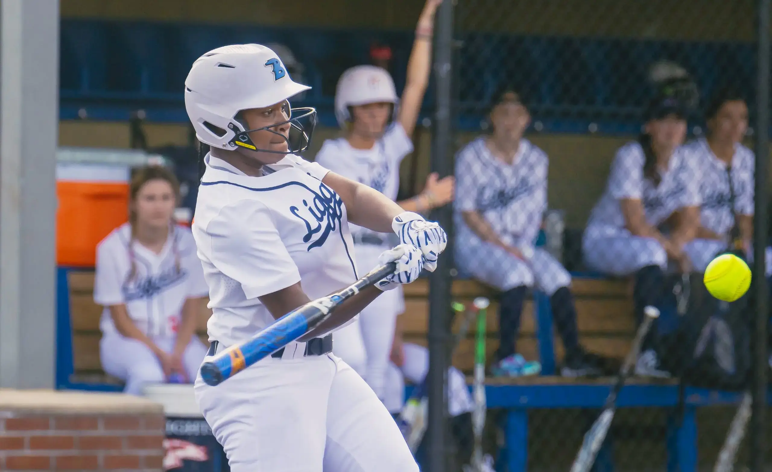 Softball player swings at a pitch