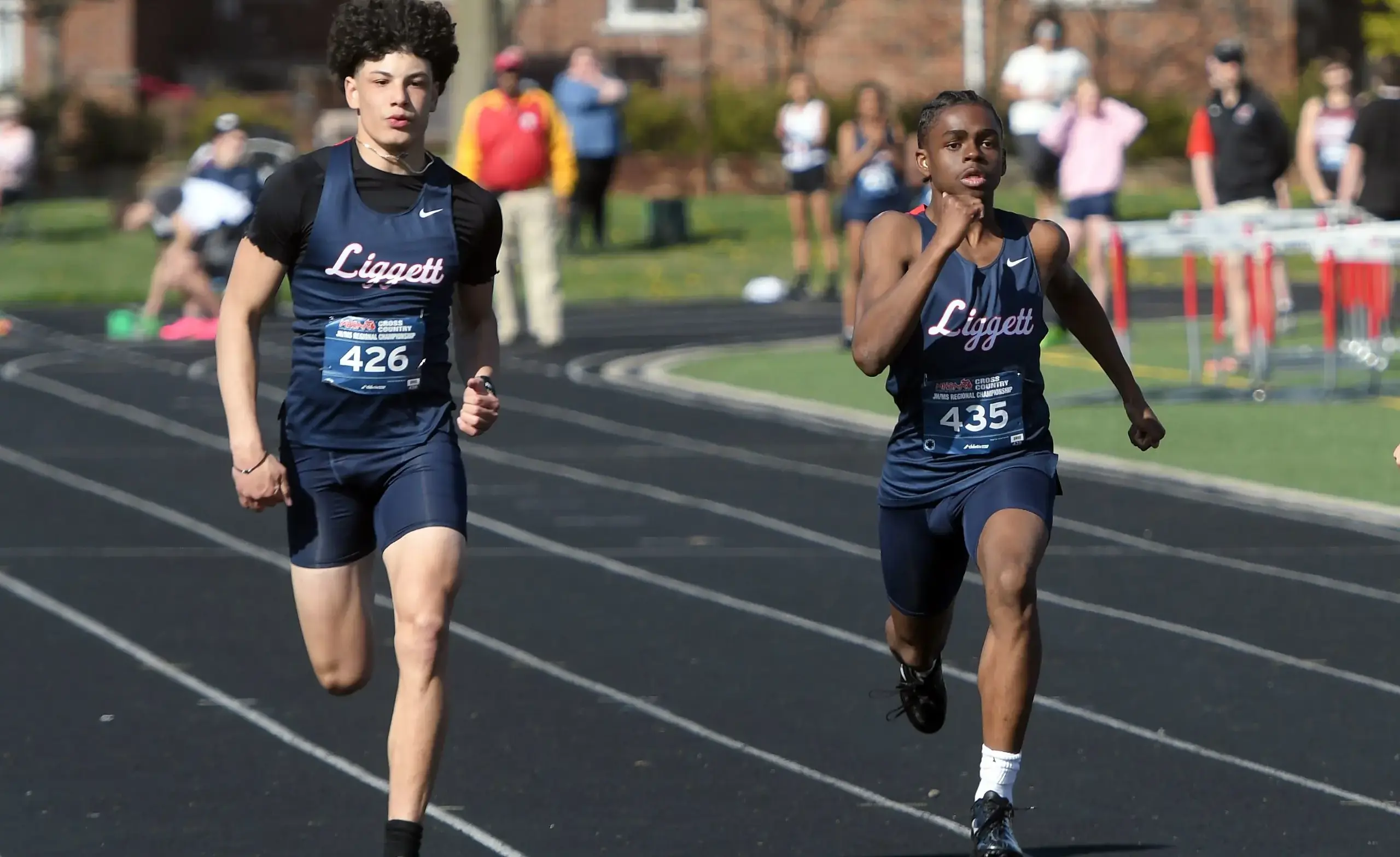 Two ULS athletes running on the track during a meet