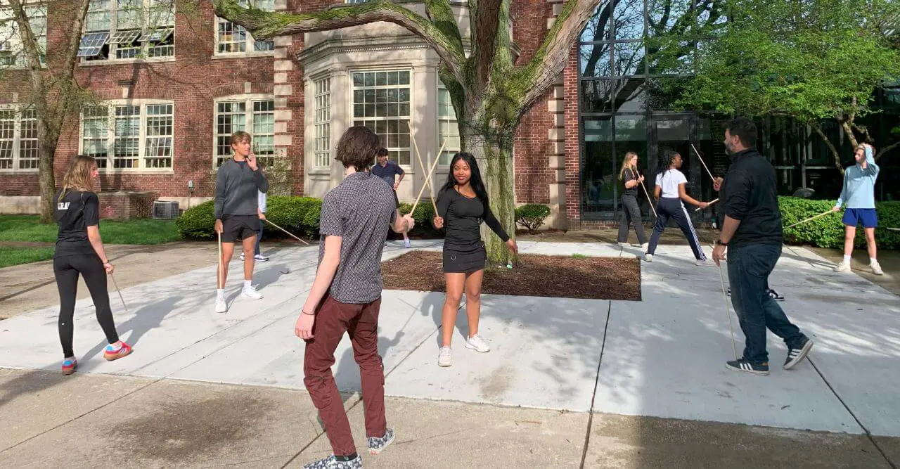 Upper School students practicing for performance with sticks as part of the Shakespeare Project.