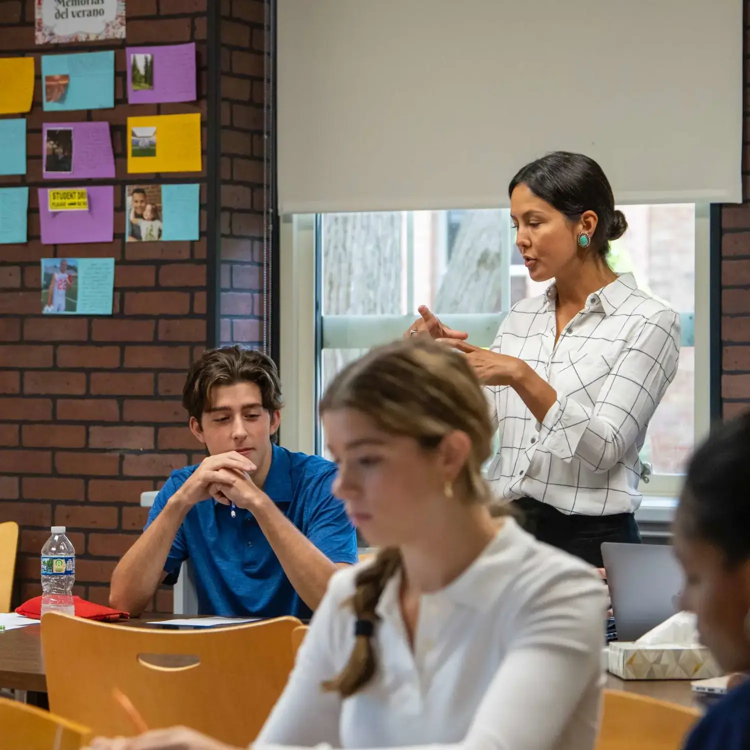 Upper School teacher talking to a student in class.