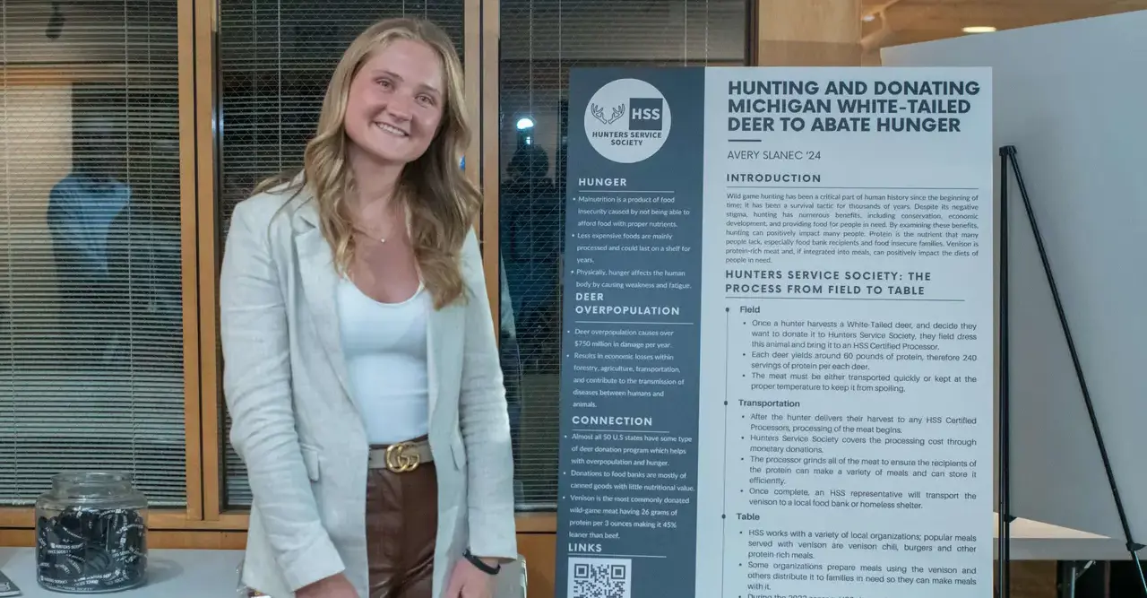 Student by board smiling