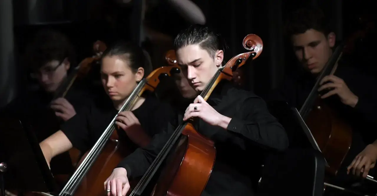 Upper School students playing cellos in the Pit Orchestra.